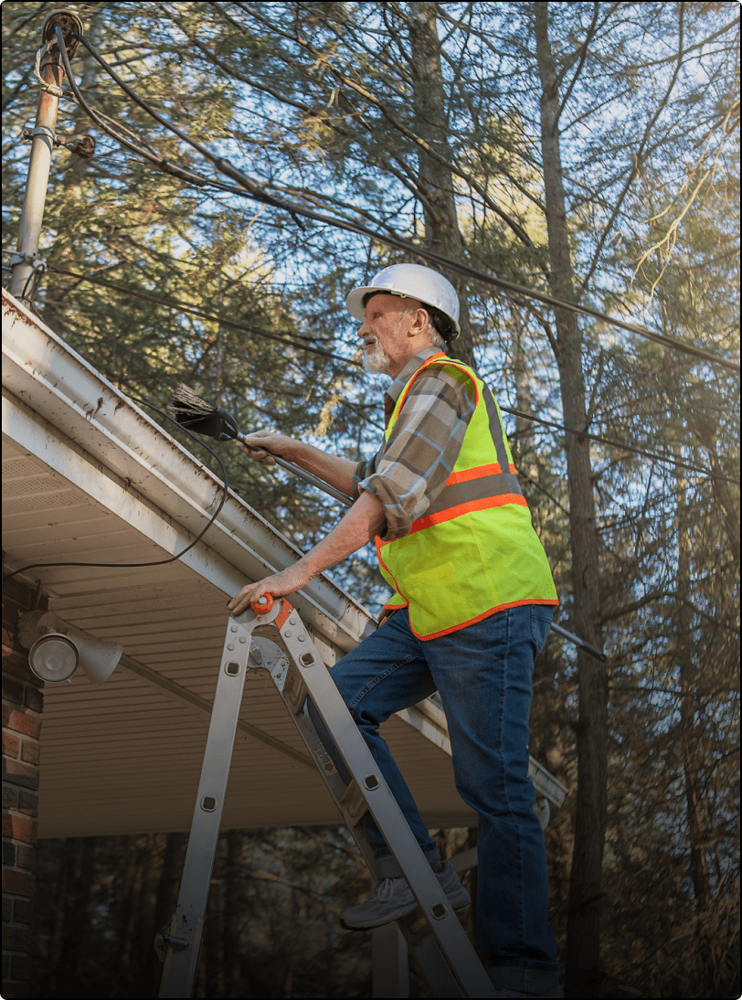 Worker fixing roof on ladder